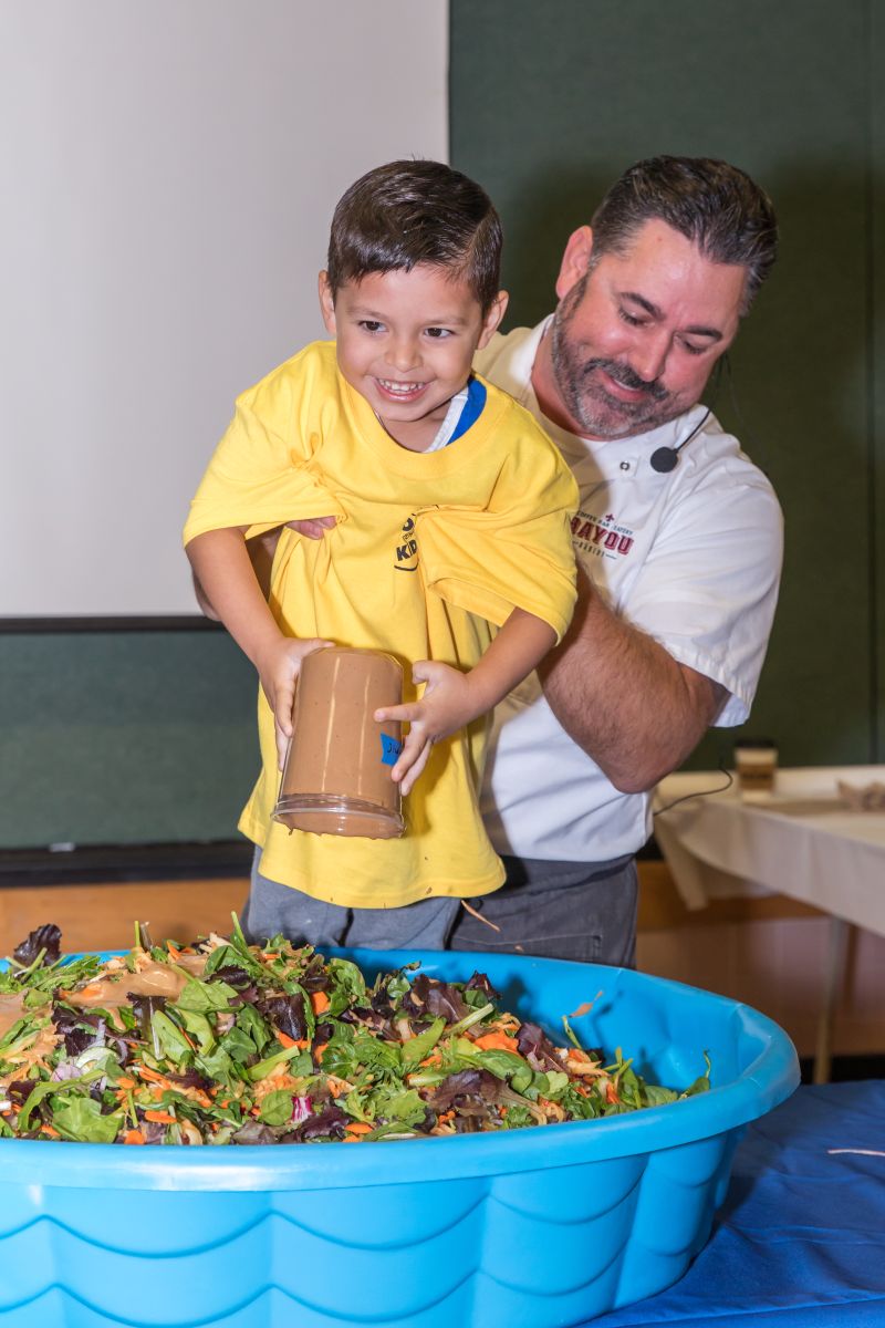 Chef David Guas gives a young helper an assist at Real Food for Kids 2018 Food Day event.